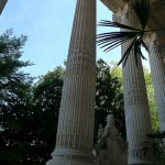 Towering columns and palm trees on the outdoor terrasse at Le Mini-Palais