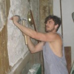 Chef James Henry peeling away wood paneling to reveal the Bones