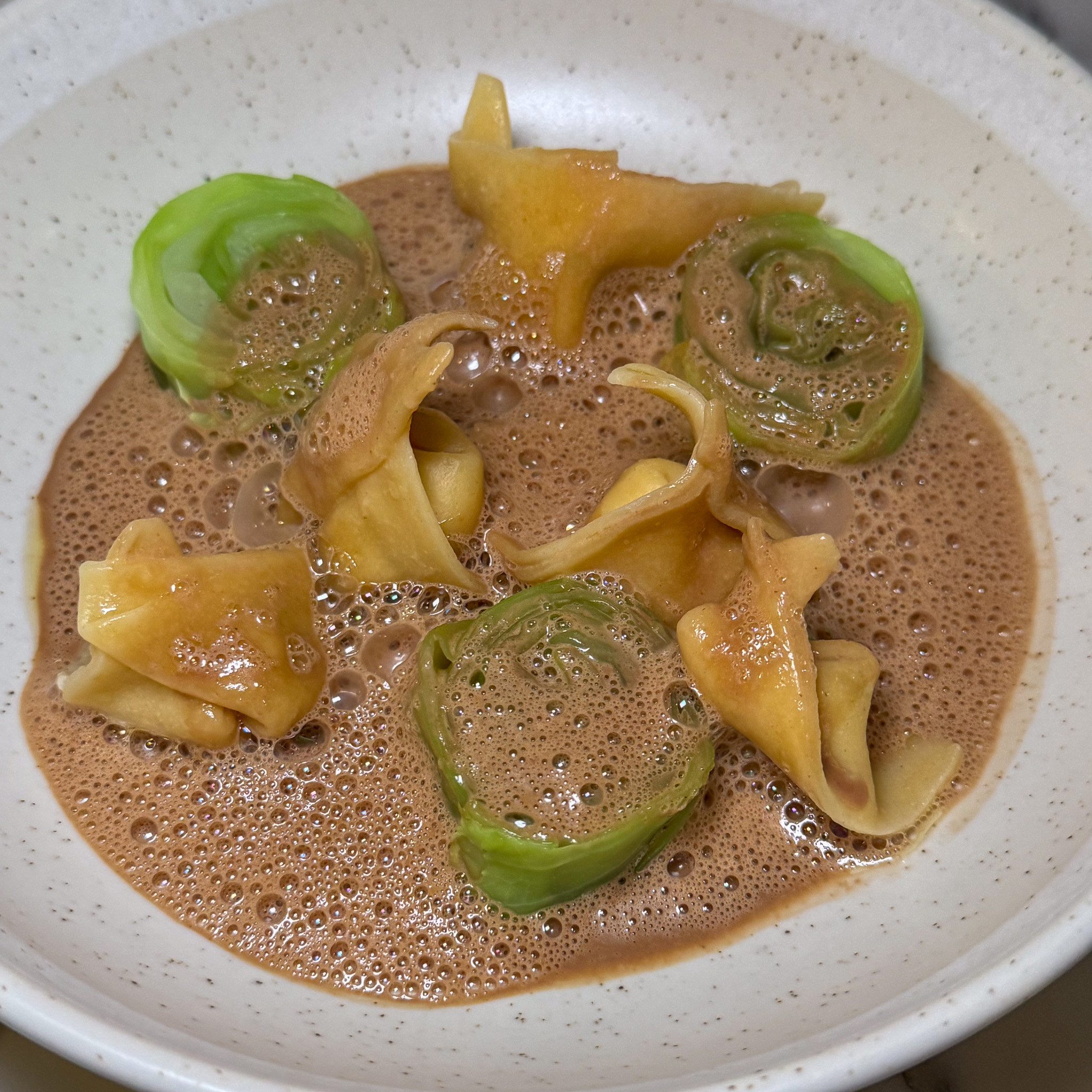 Langoustine cappelletti and rolled green cabbage in a frothy langoustine bisque