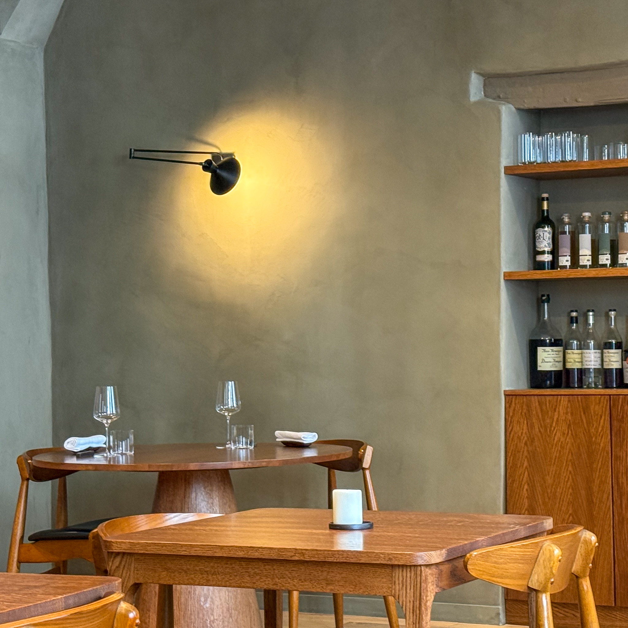 Interior: Dining room at Eme, Paris Marais — walnut tables and sage-grey walls