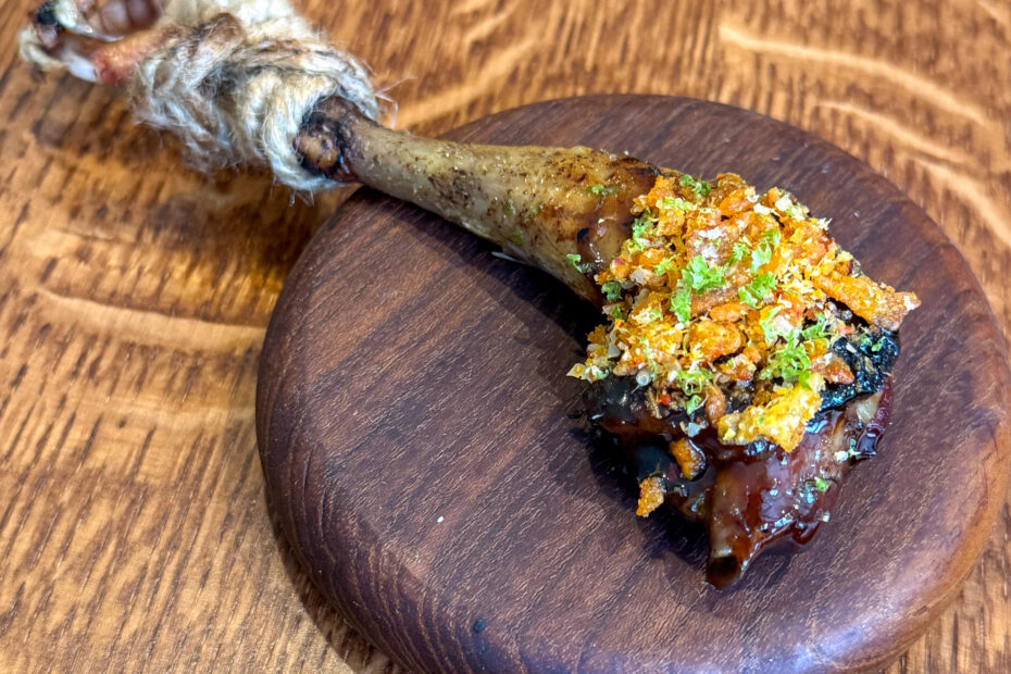 Pigeon leg on walnut board at Eme restaurant, Paris 4th