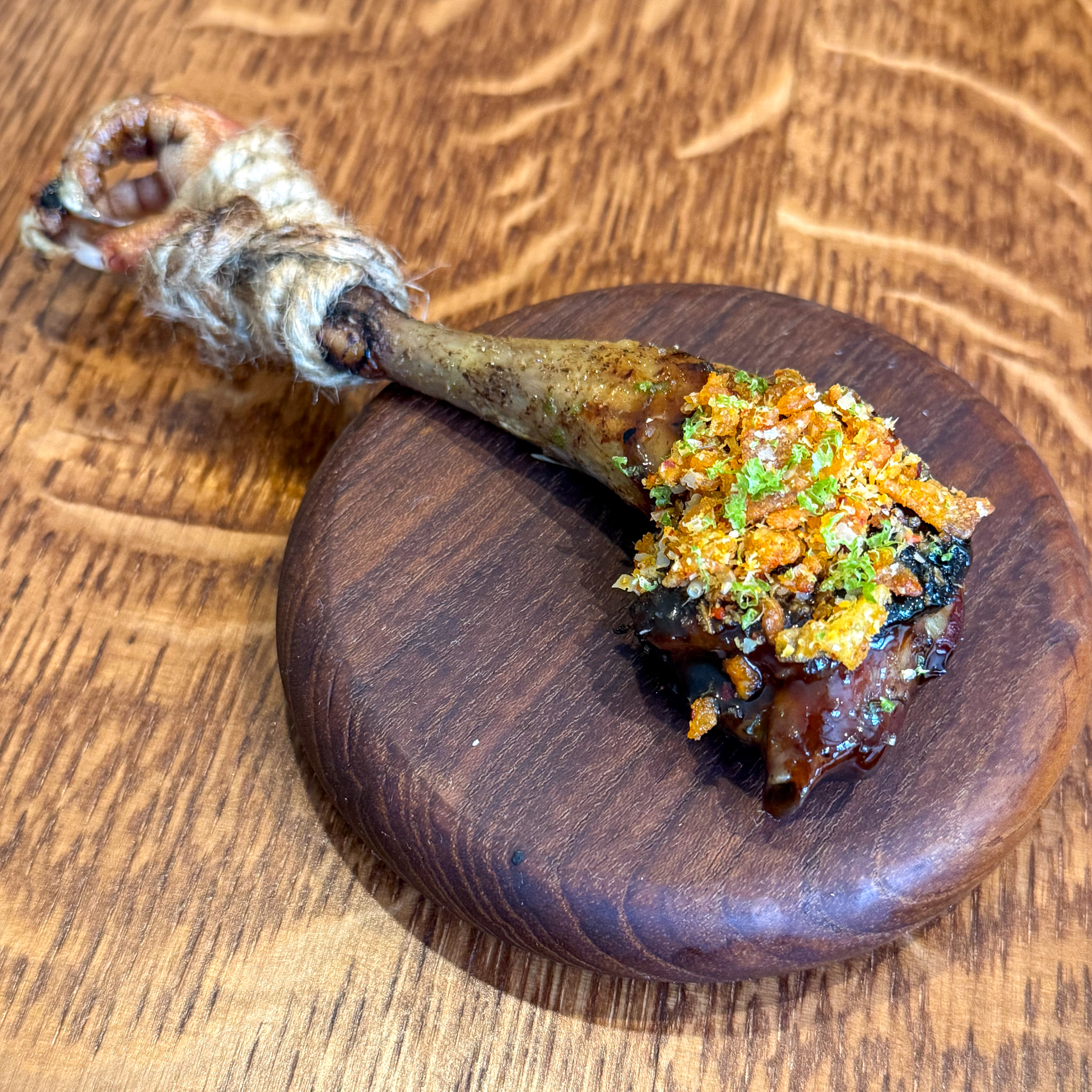 Pigeon leg on walnut board at Eme restaurant, Paris 4th