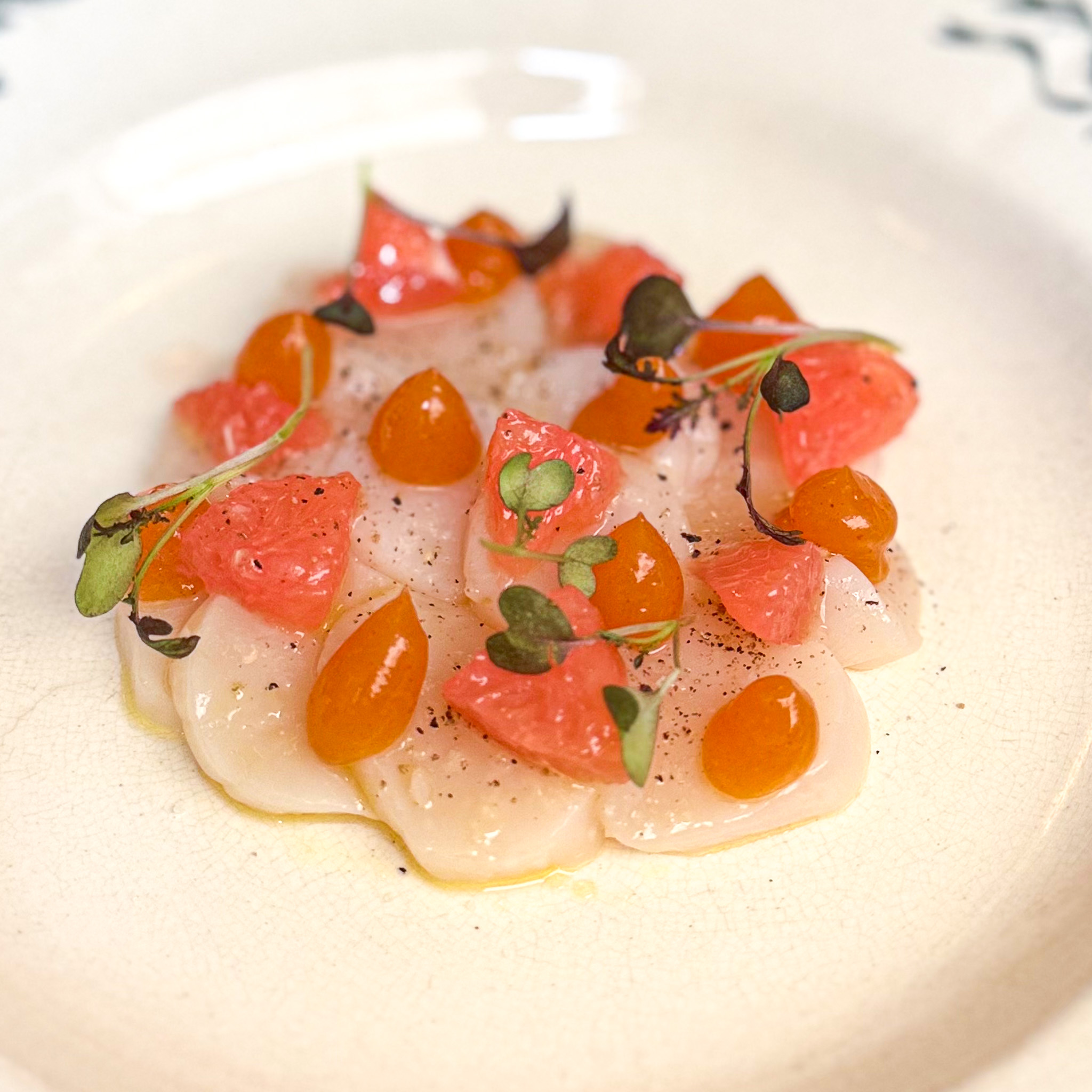 Sea scallop carpaccio with pomelo segments, pomelo gel, micro-herbs and yuzu salt at Le Bon Saint-Pourçain, Paris 6th