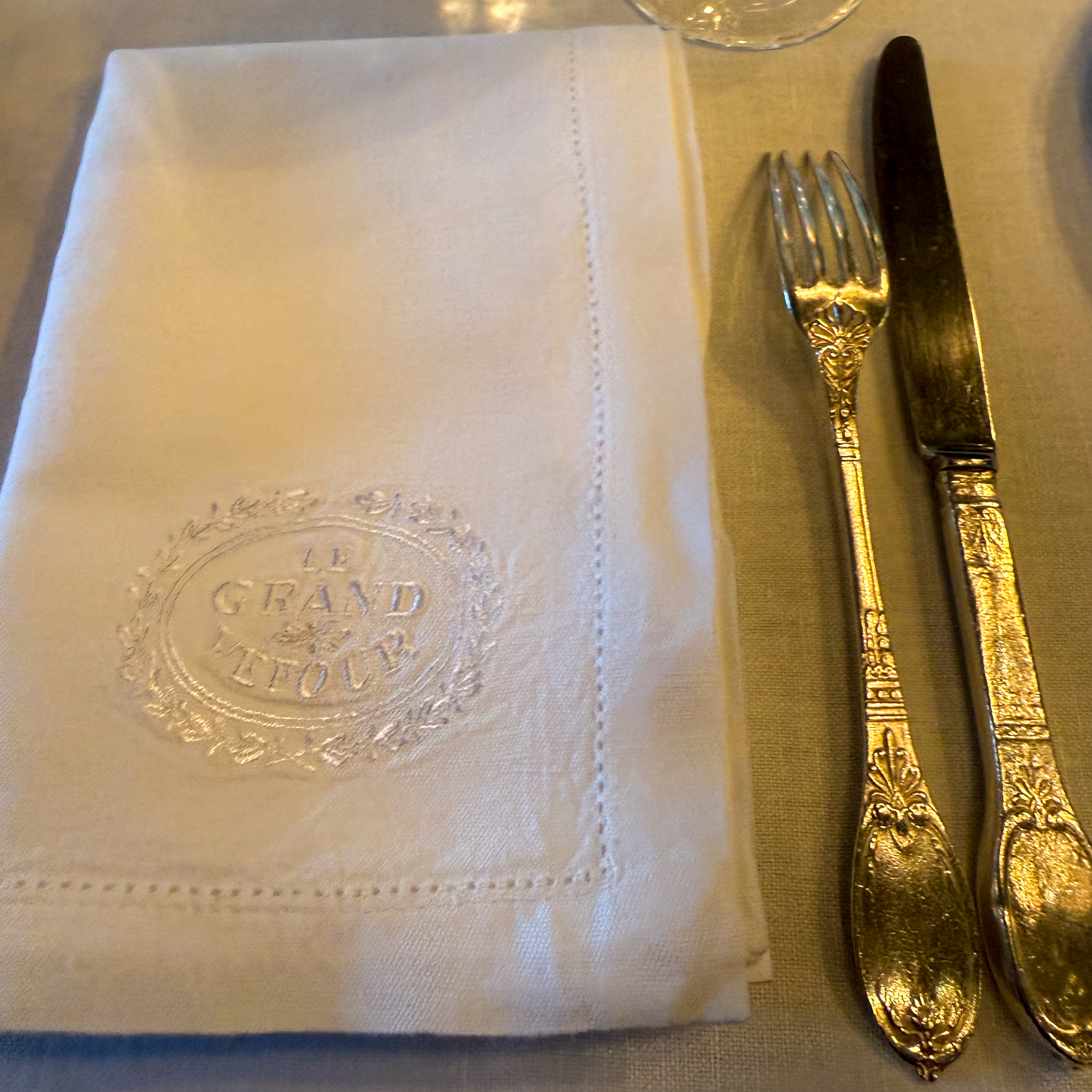 place-setting-le-grand-vefour-restaurant-paris | PARIS BY MOUTH A place setting at Le Grand Véfour: crested blue-and-white porcelain, engraved crystal, and linen embroidered with the restaurant's name.